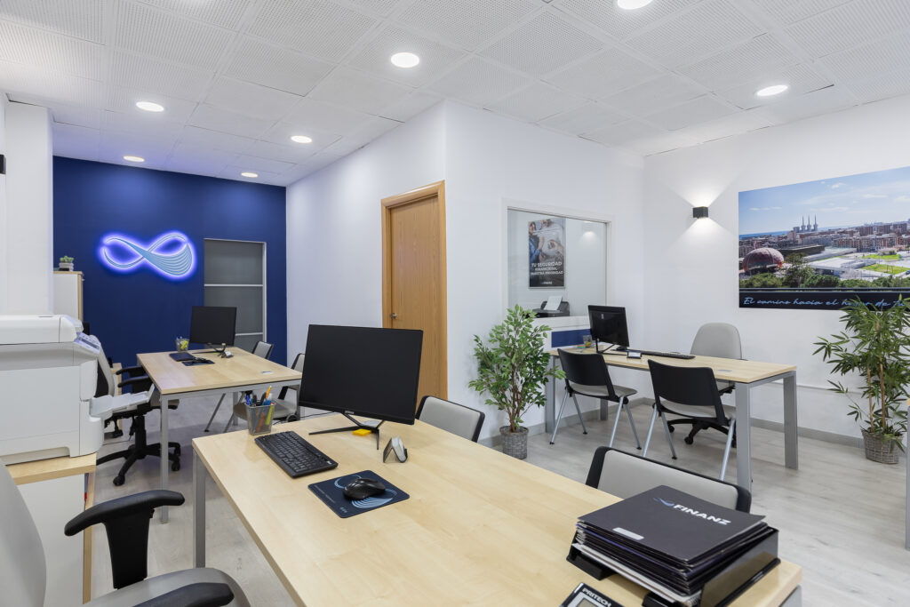 Vista amplia de la oficina Finanz con puestos de trabajo y detalles de marca.