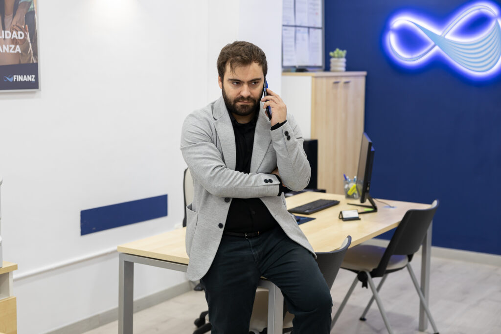 Asesor de Finanz atendiendo una llamada en la oficina.